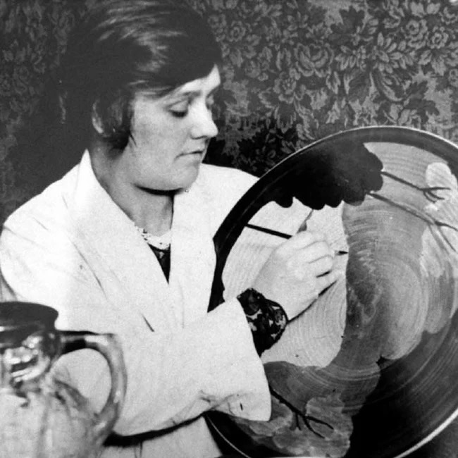 Clarice Cliff painting a platter in the 1930s.