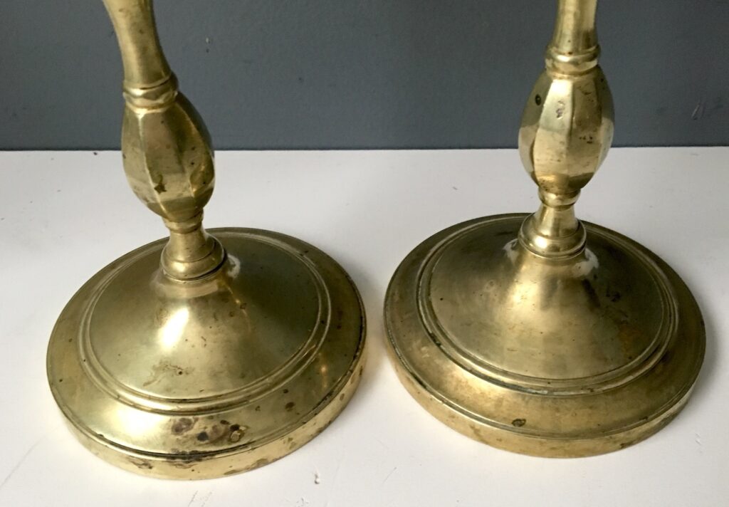 Brass candlestick bases with pitting.