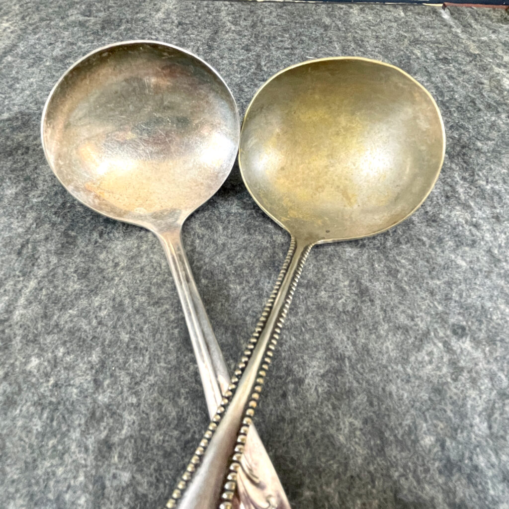 Pair of silver plate tableware ladles with the silver worn off the bowls.